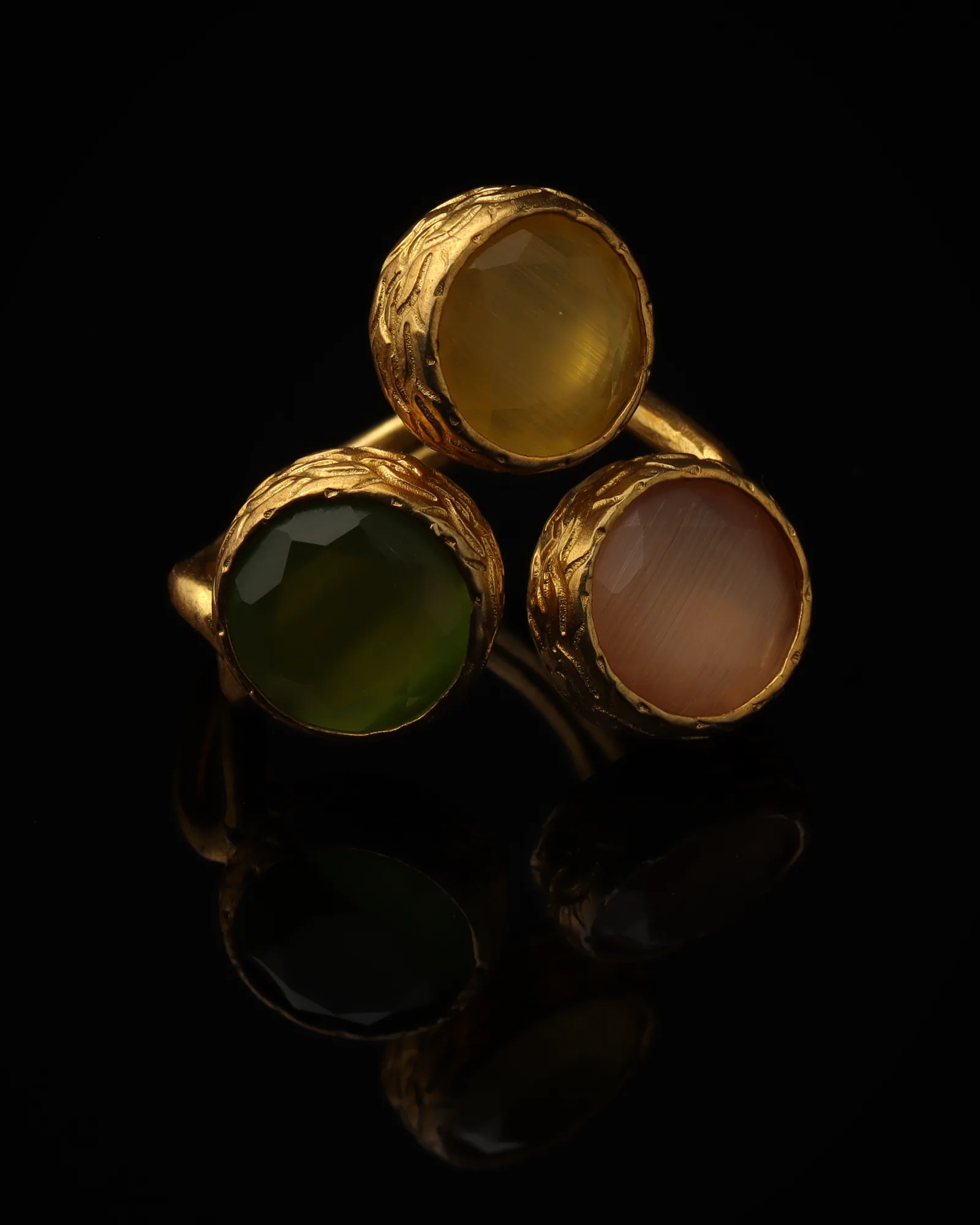 Apricot & Clover - a gold-plated ring with three orange and green cat eye stones, on black