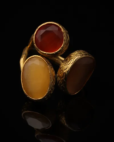 Rust & Camel - a gold-plated ring with three red and brown cat eye stones, on black