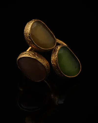 Willow & Mauve - a gold-plated ring with three green and purple cat eye stones, on black