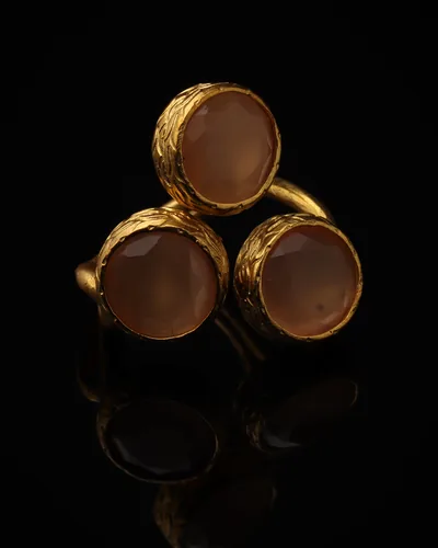 Clay & Fawn - a gold-plated ring with three orange and brown cat eye stones, on black